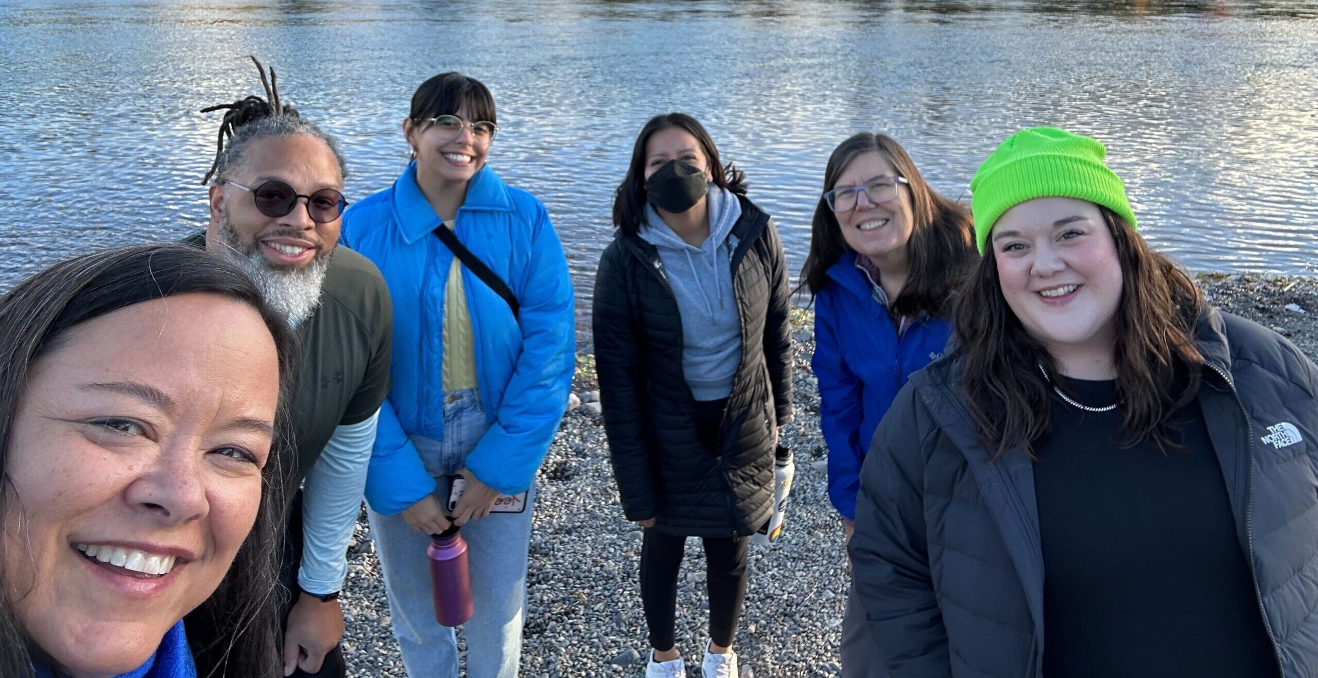 Policy cohort and OCJ staff smile at the camera while walking by water