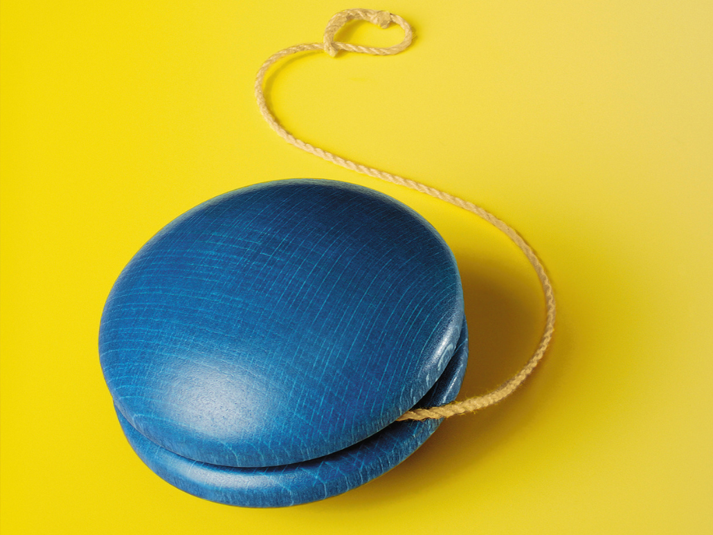 Blue wooden yo-yo on a yellow background.