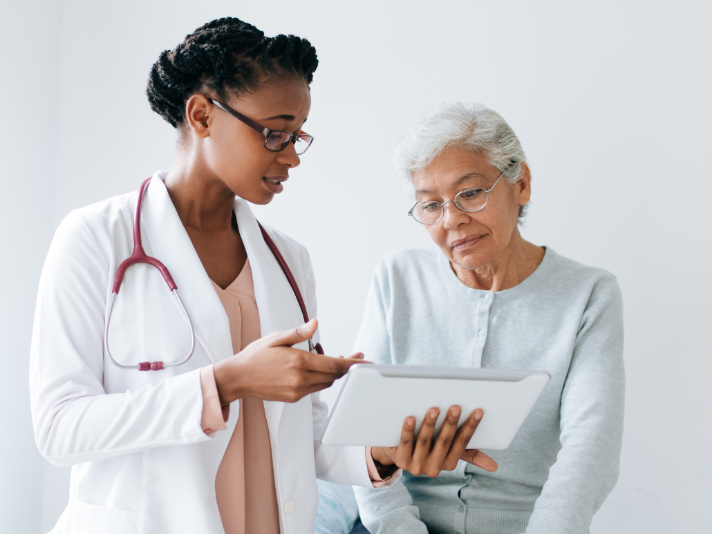 Doctor showing a tablet to an older patient.