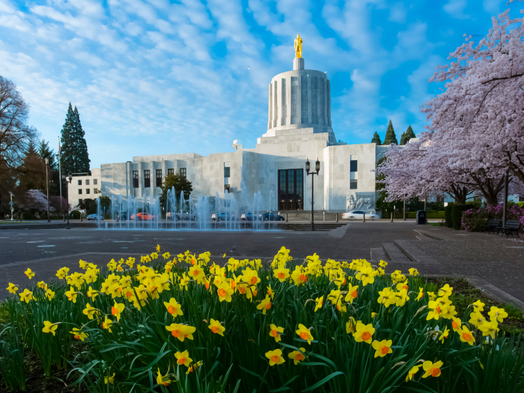 Oregon State Capitol building with yellow flowers in the foreground.