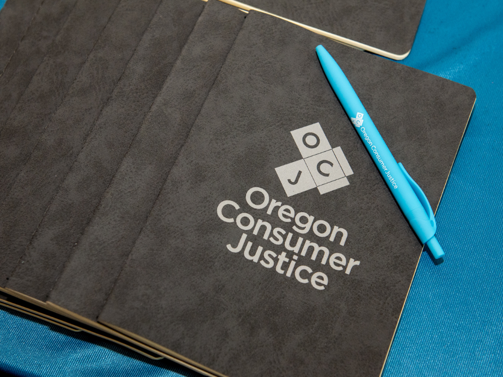 Oregon Consumer Justice notebook and pen on a table.