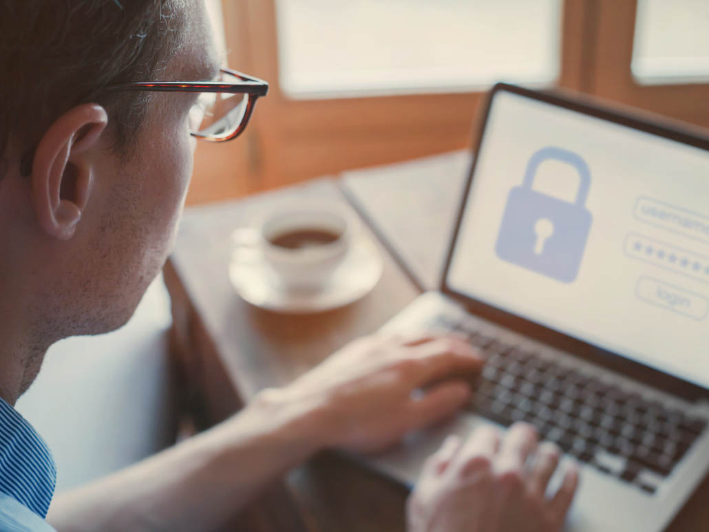 A man works at a computer displaying a secure login.