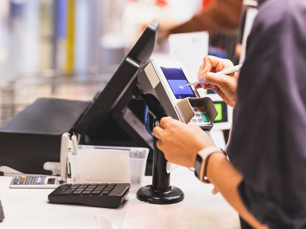 A person using a credit card at a cash register.