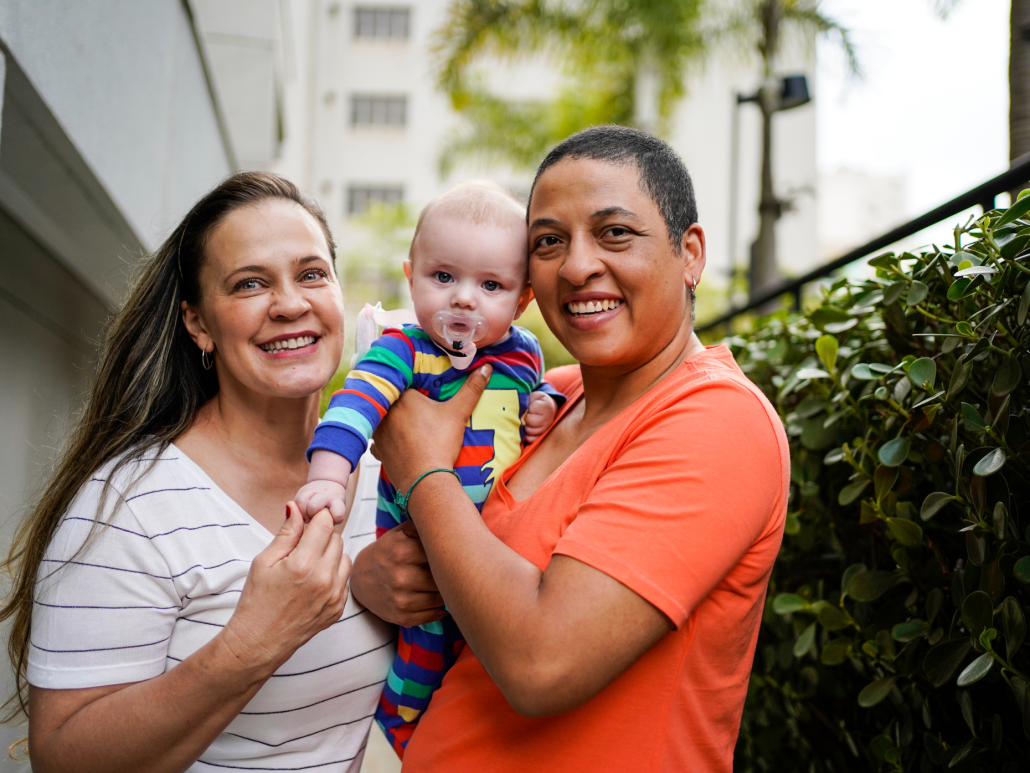  Two people and a baby smile for the camera.