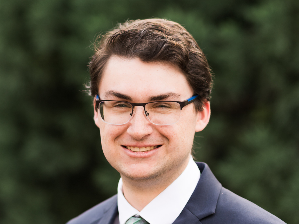 吉在户外砖柱附近微笑的大头照。