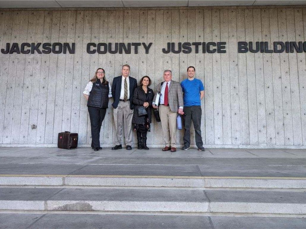 Image of attorneys and client in front of courthouse
