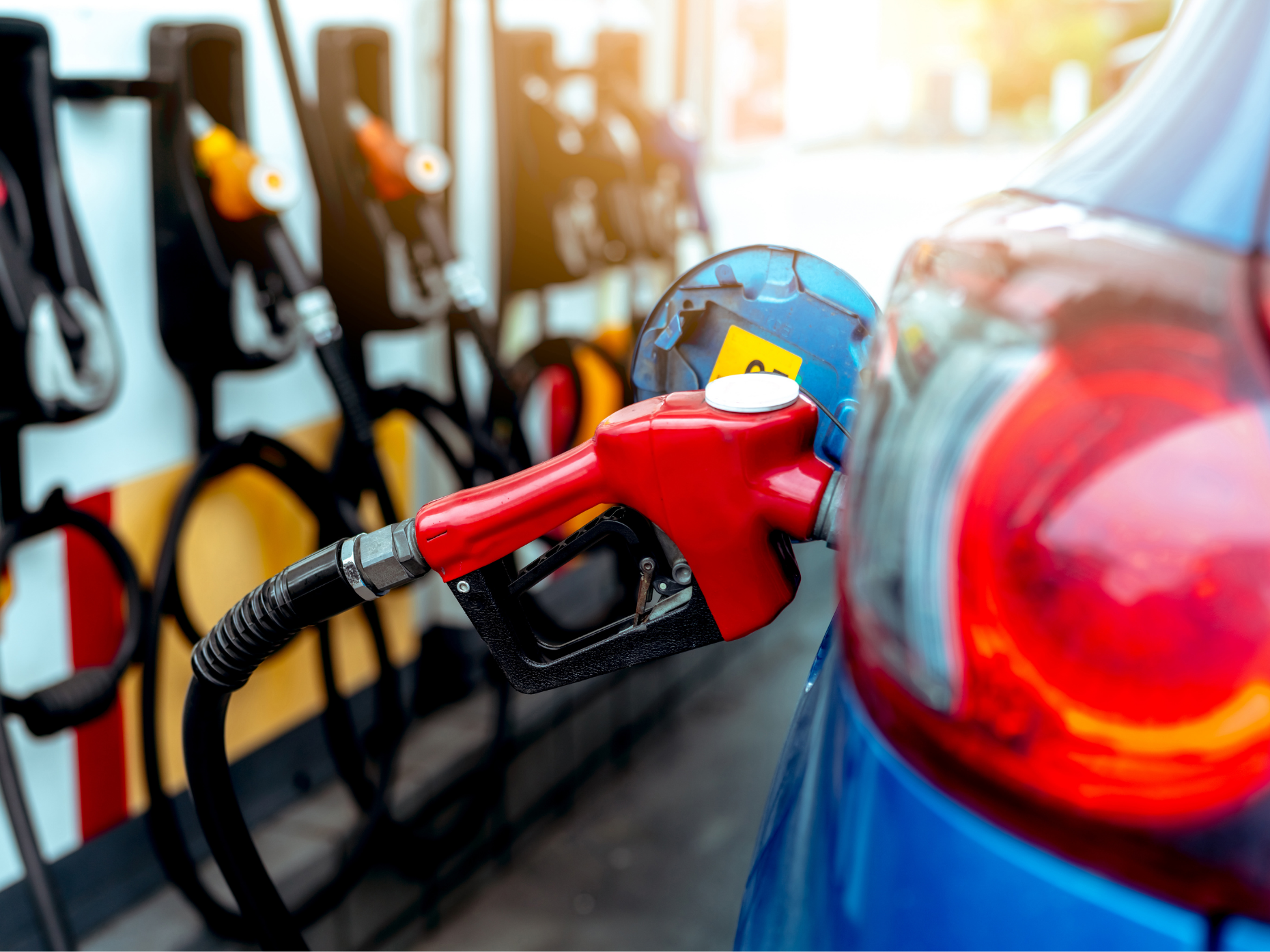 Gas pump nozzle inserted into a car.