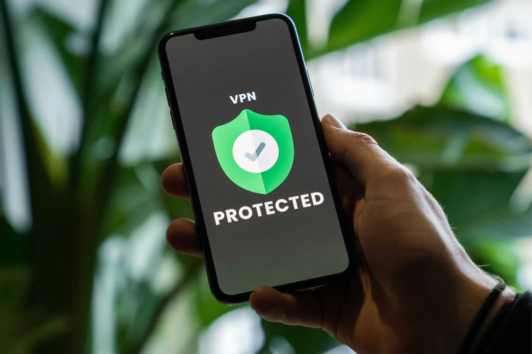 A picture of a hand holding a phone with "protected" on the screen.