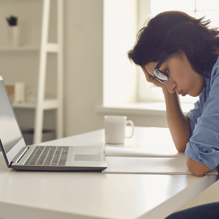 Exhausted young woman reading a fine print agreement with her hand on her head. 