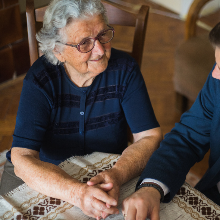 An older person and an attorney sitting together at a table