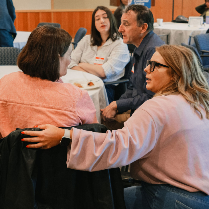 A group of people talking around a table in a conference room