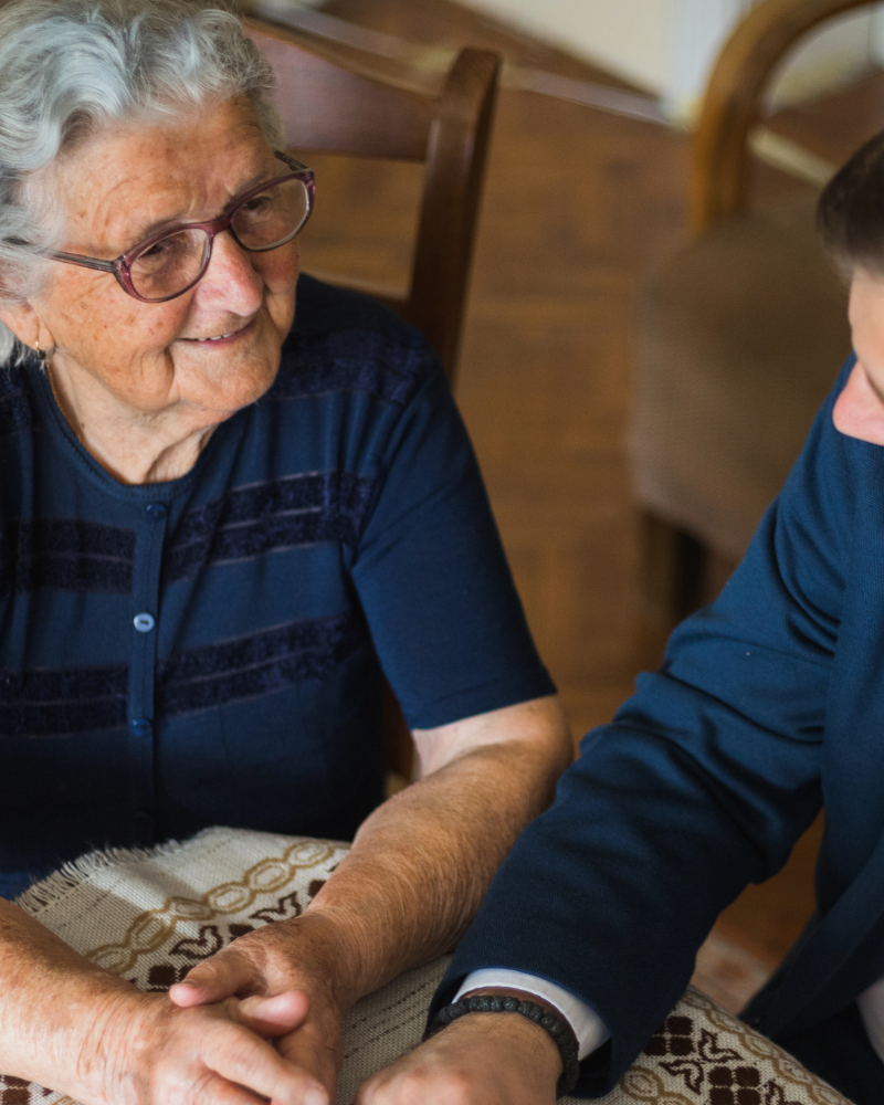 An older person and an attorney sitting together at a table